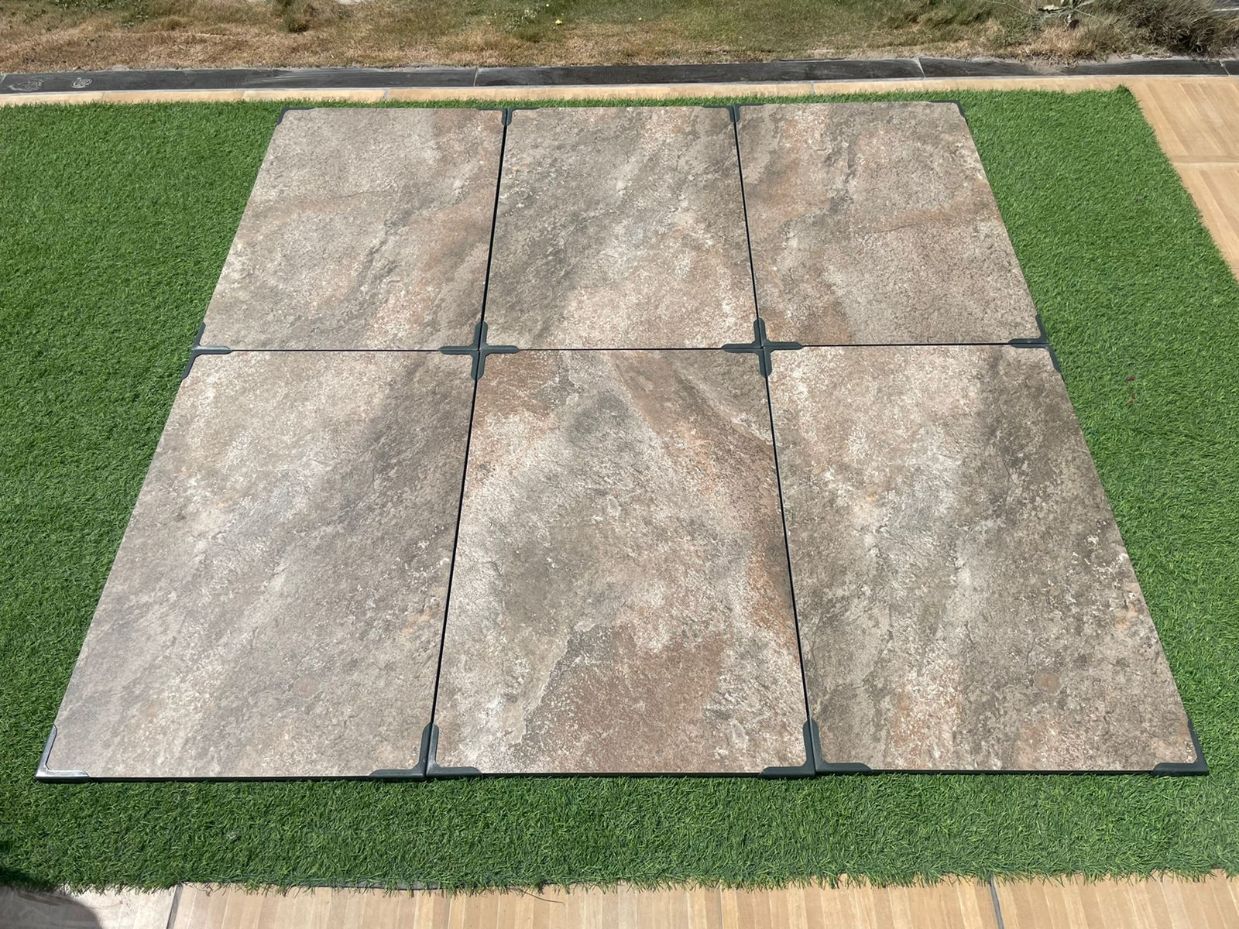 Rough Bruno porcelain paving slabs on grass