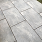 Earthcore Grey porcelain paving slabs on patio with grass