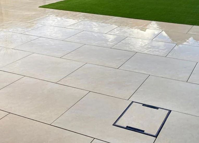 Hammerstone Beige porcelain paving slabs on wet patio