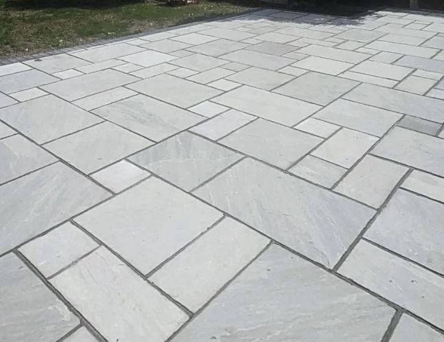 Kandla Grey sandstone paving slabs in mixed sizes on patio